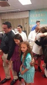 A group of people gathered around a man and a woman, engaged in conversation