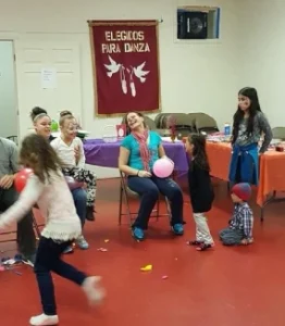 A lively group of individuals joyfully playing with colorful balloons in a spacious room filled with laughter and excitement